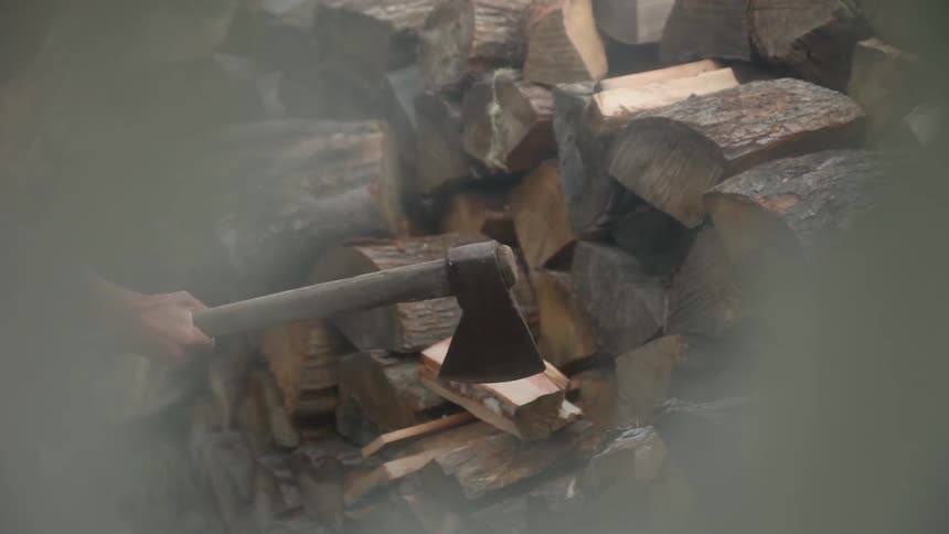 A man chops firewood with an ax