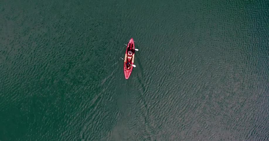 Two people in a boat row together