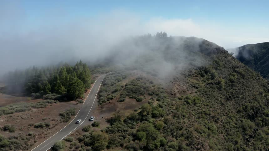 A car drives up a mountain road