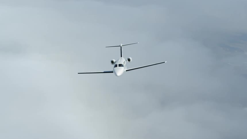 A luxury jet is flying above the clouds during the day