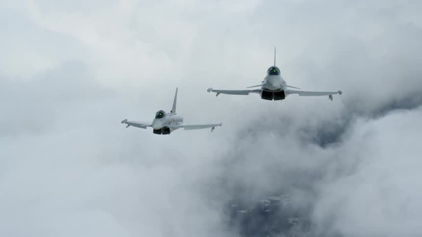 Two airplanes hover in the sky over the clouds
