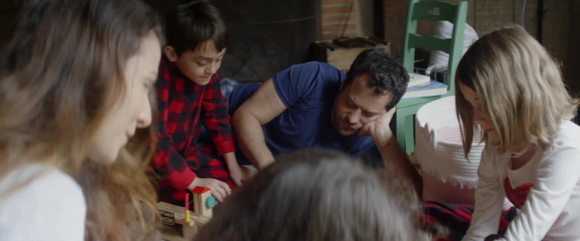 A family plays and reads on a living room floor
