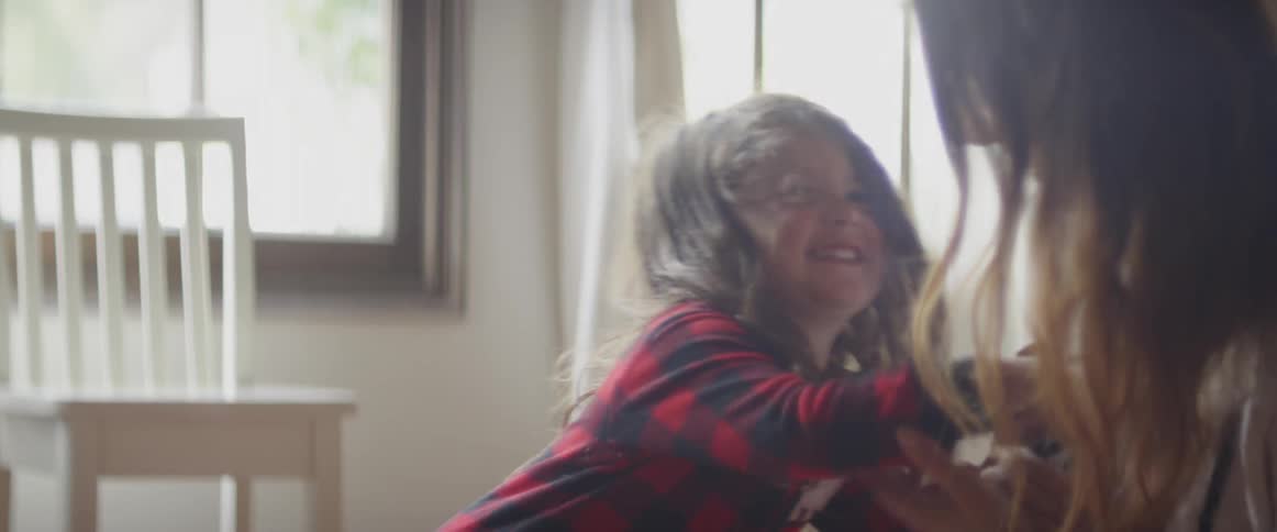 A mother is playing with her daughter inside in daylight