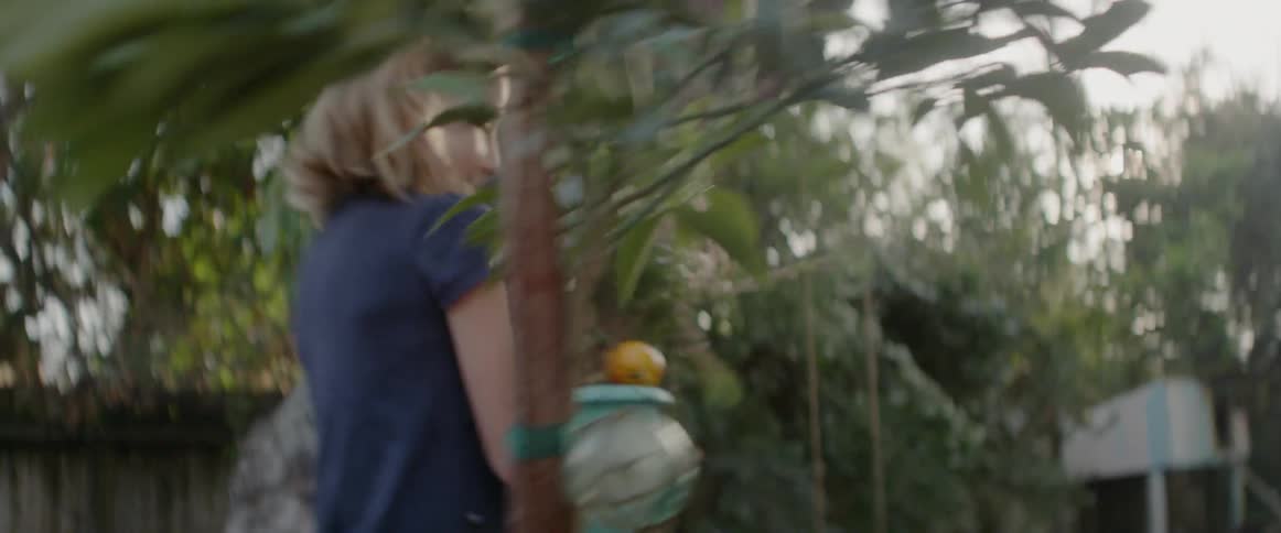 Young girl carries a potted plant and sets it on a table