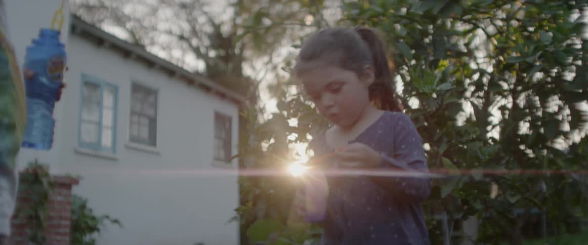 Children are blowing bubbles in a backyard at dusk