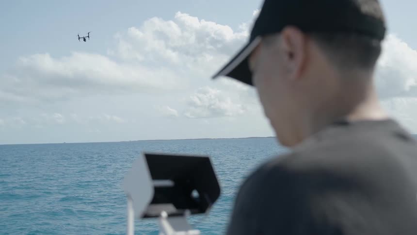 Man flies a drone over the water