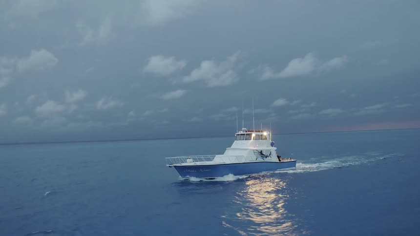 Boat cruises on the open water on a cloudy day