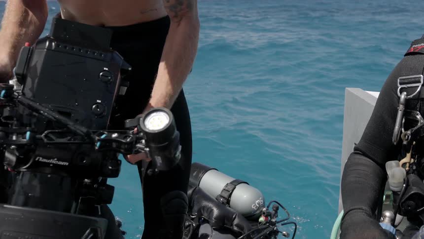 A scuba diver climbs onto a boat