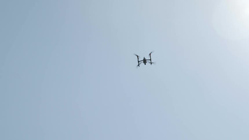 The drone is flying high in the sky