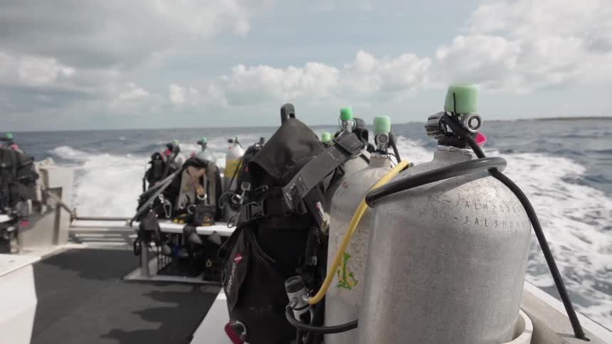A boat carrying air canisters travels on the water