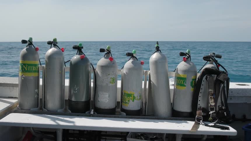 Oxygen tanks are lined up on a ship on the ocean