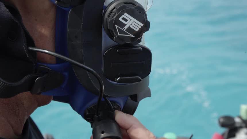 Man wears a diving mask while standing on a boat