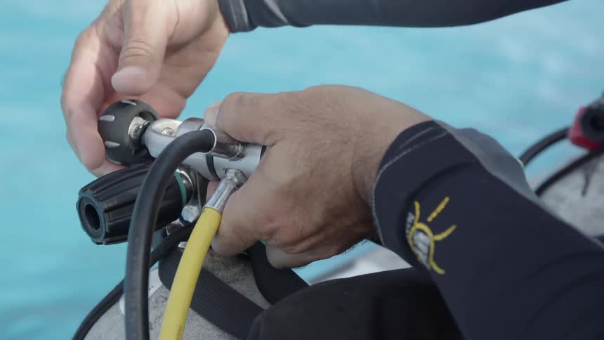 A person tightens the valves on his diver gear