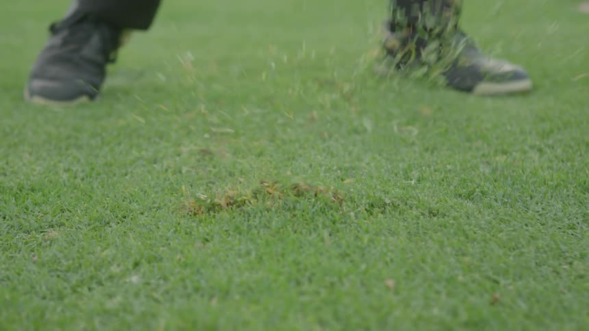 Man drives a golf ball on some green