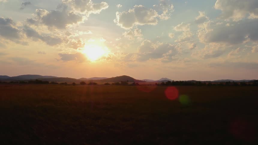 The sun sets over a rural landscape