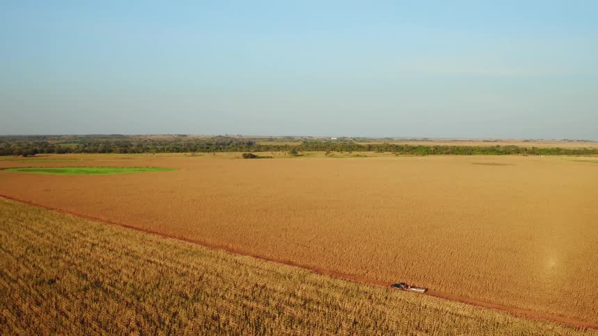 A truck pulls a boat through a rural field