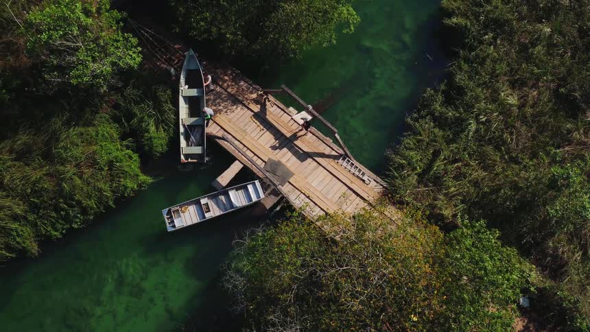 Men move a boat from a bridge into a creek