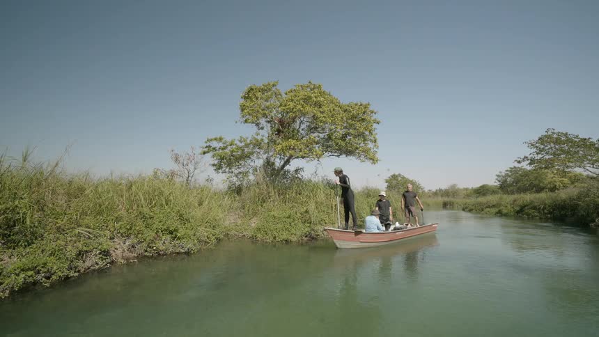 Men ride a boat down a river