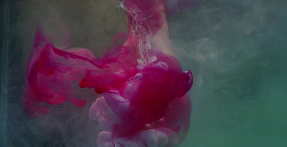Red and white ribbons of paint float around a hand in water