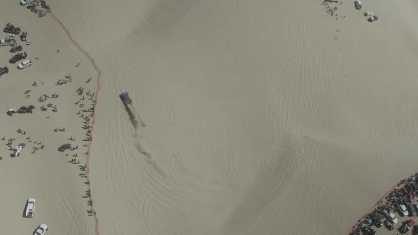 A car is driving in a desert
