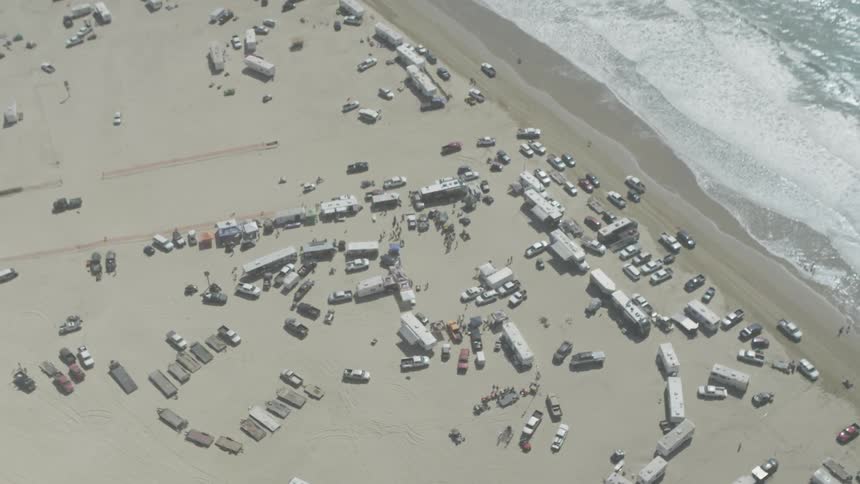 Cars and recreational vehicles sit on a beach