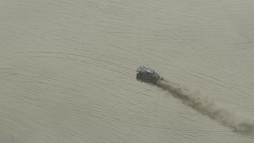 A car is driving through a desert