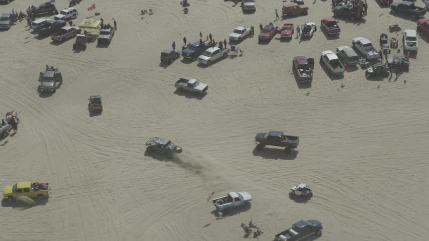 Aerial view of people and vehicles on a large beach