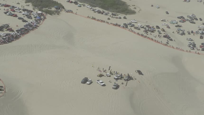 A large group of people gather in the desert