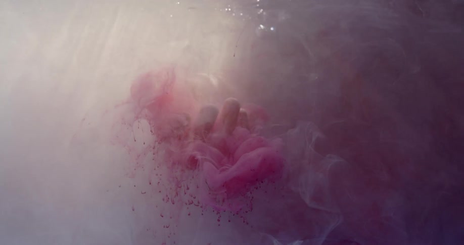 Clouds of paint float in a palm in water