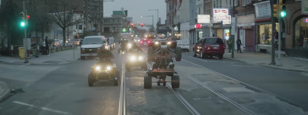 A group of men ride atvs on a city street