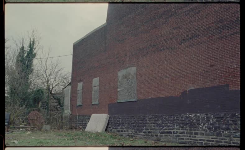 Boards cover windows on a brick building