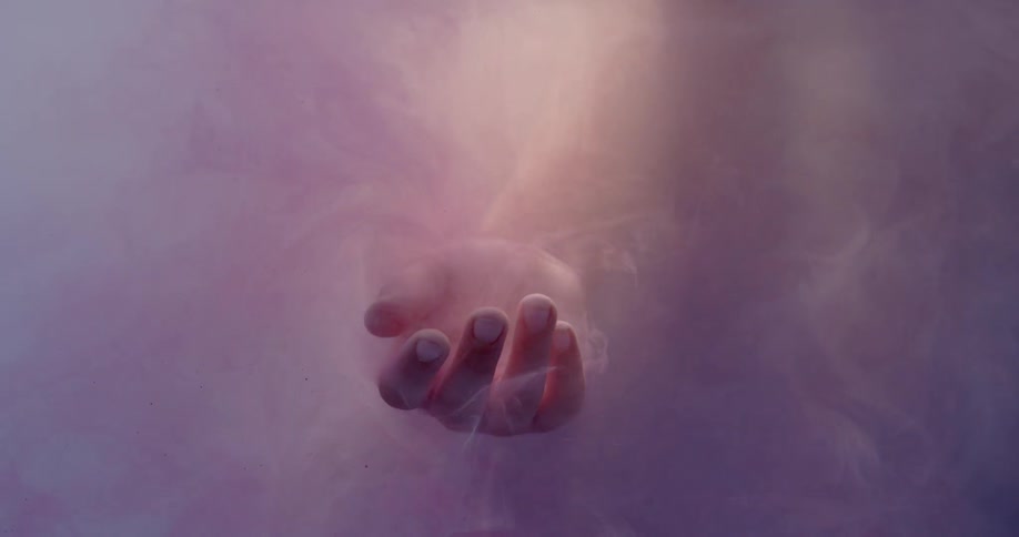 A person's hand dips into the fog