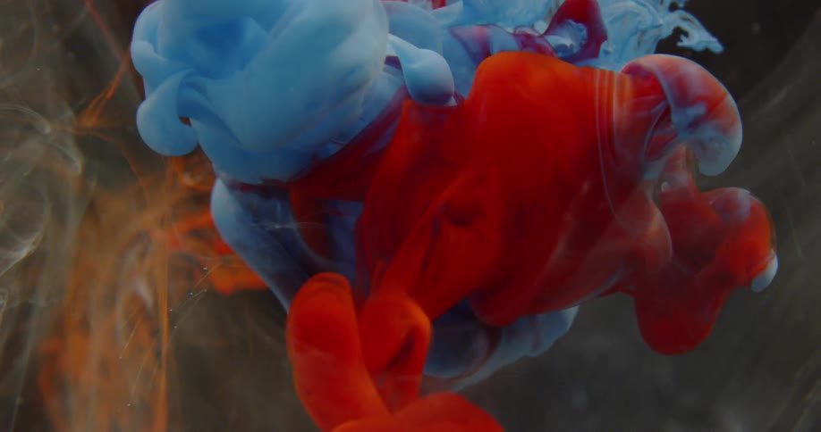 Red and blue dye swirl through water