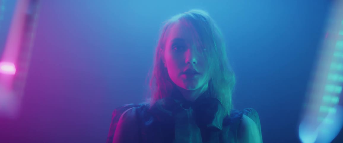 The woman walks forward under the light