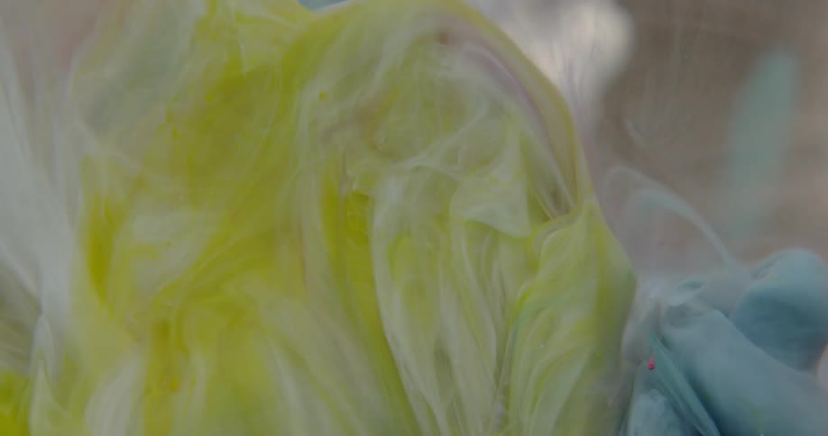 Dye in a liquid solution is swirling in a colorful pattern