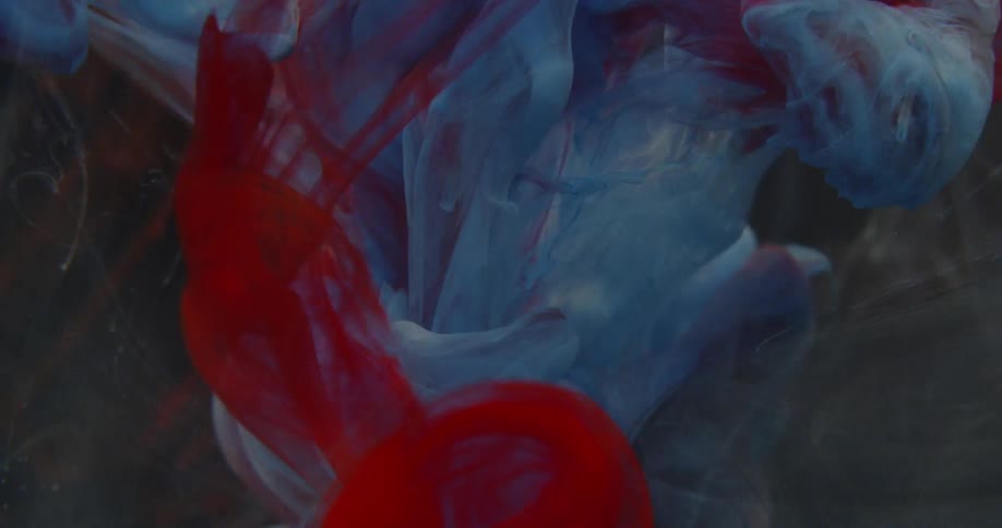 Blue and red ink fills the water