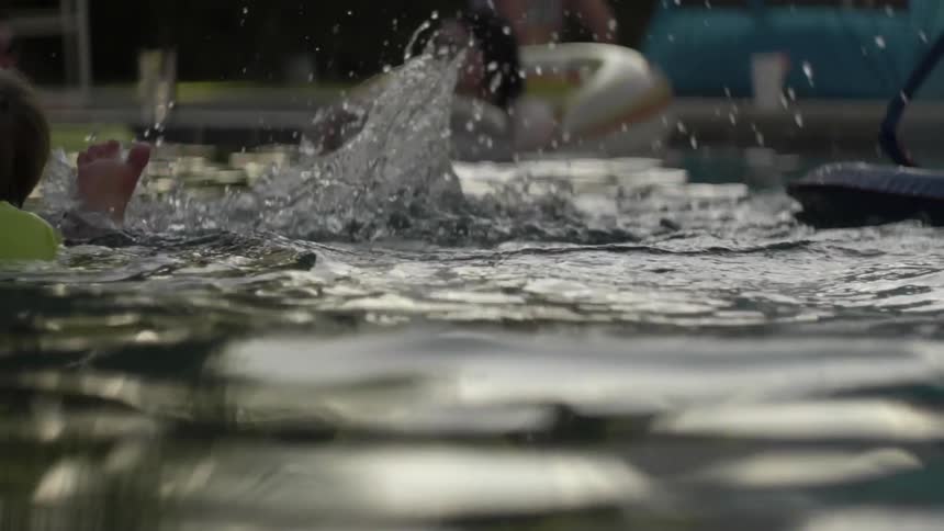 Kids play and splash water in a pool