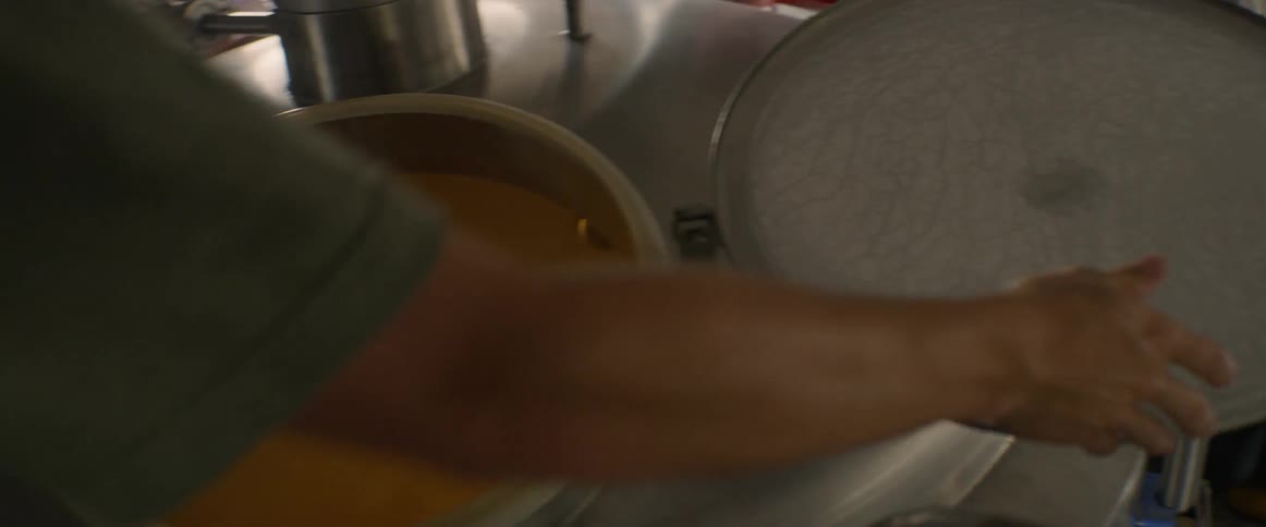 A person opens the vat in the brewery