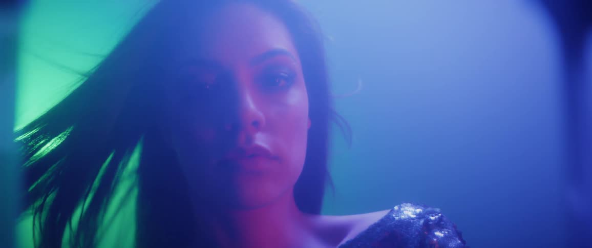 A woman looks seductively in a sparking dress