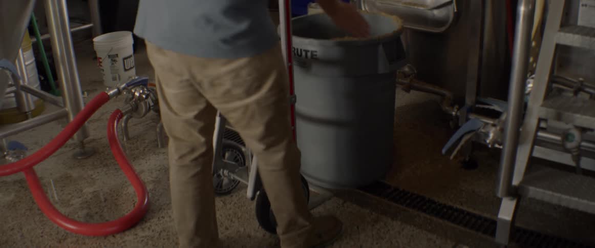 A man rolls a handcart in a warehouse