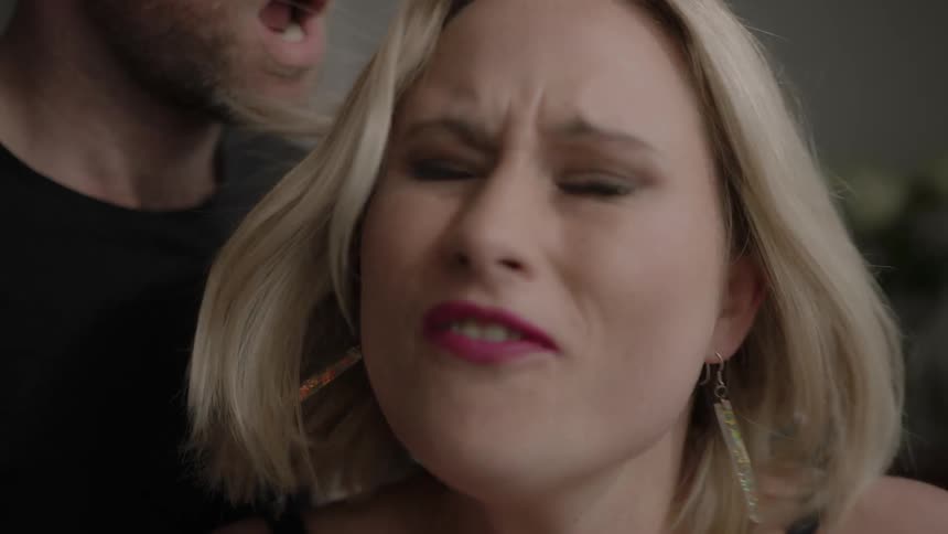 A woman angrily turns around a faces a man behind her