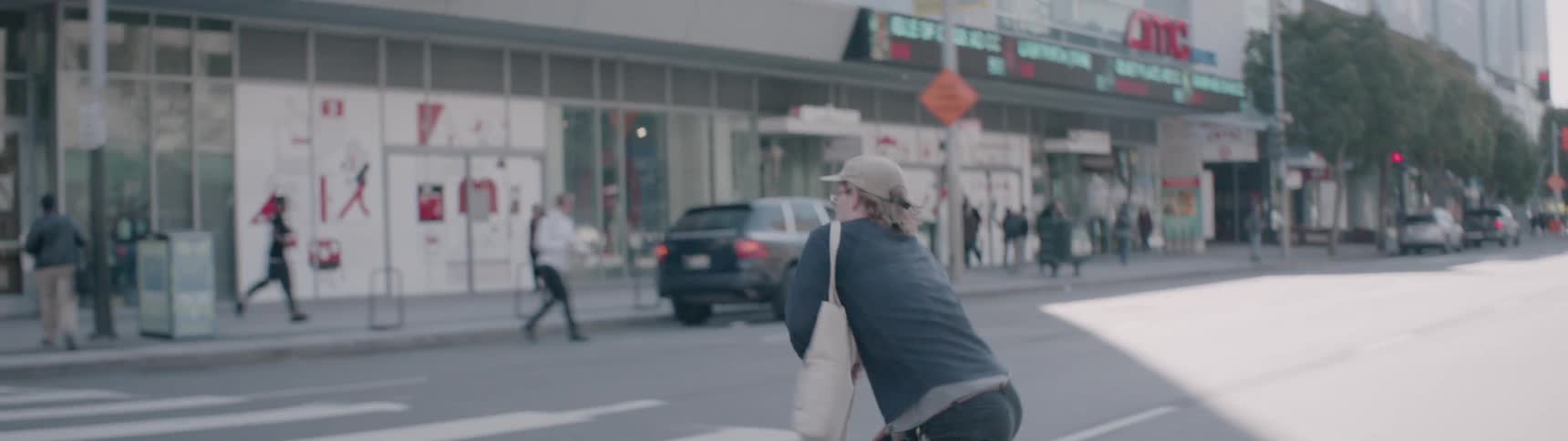 The man is riding his skateboard fast down the busy city street