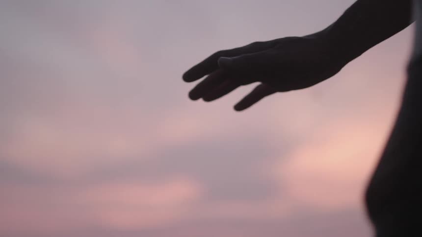 Person holding his hand in the air on a cloudy day