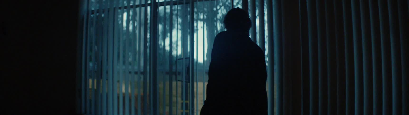 A person walks over to the window looking out