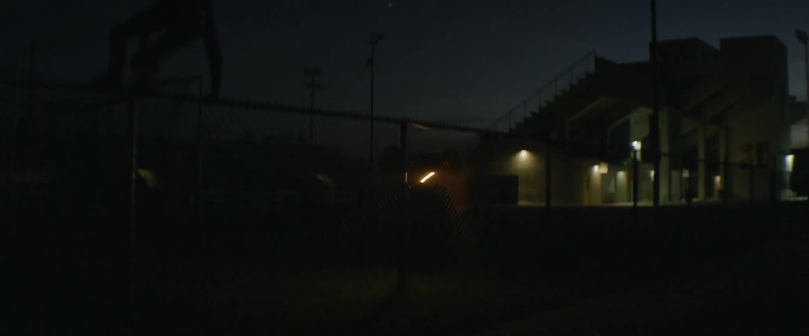 A light glows on a lawn at night