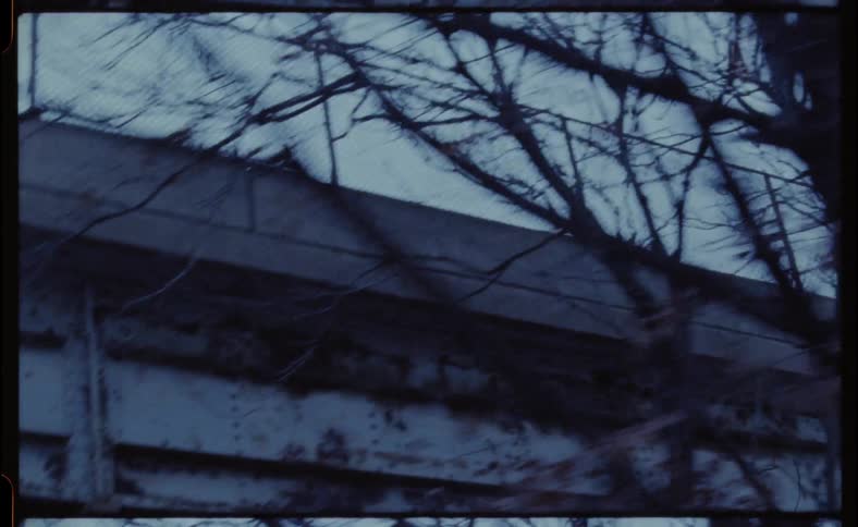 Four wheelers drive underneath a bridge in a city at night