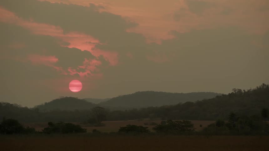 The sun is setting behind the hills