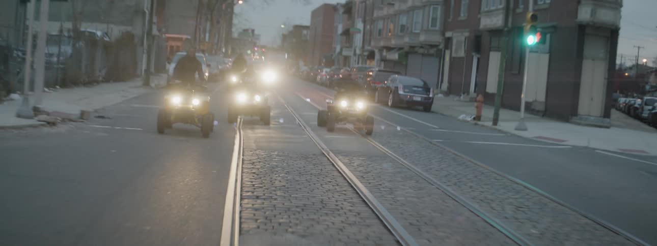 Four wheelers are driven on a city street