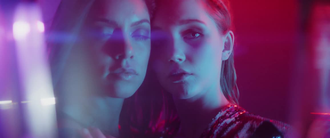 Two women embrace in a club