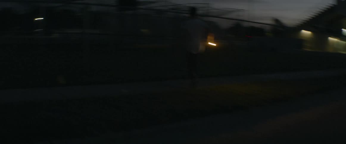 A boy carrying a flashlight climbs over fences as he runs